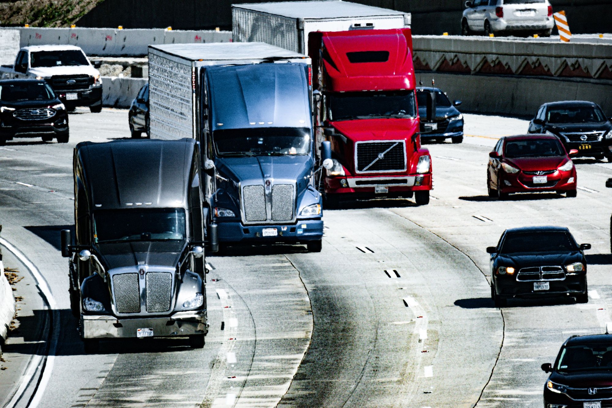 American freight trucks traveling on a busy urban highway
