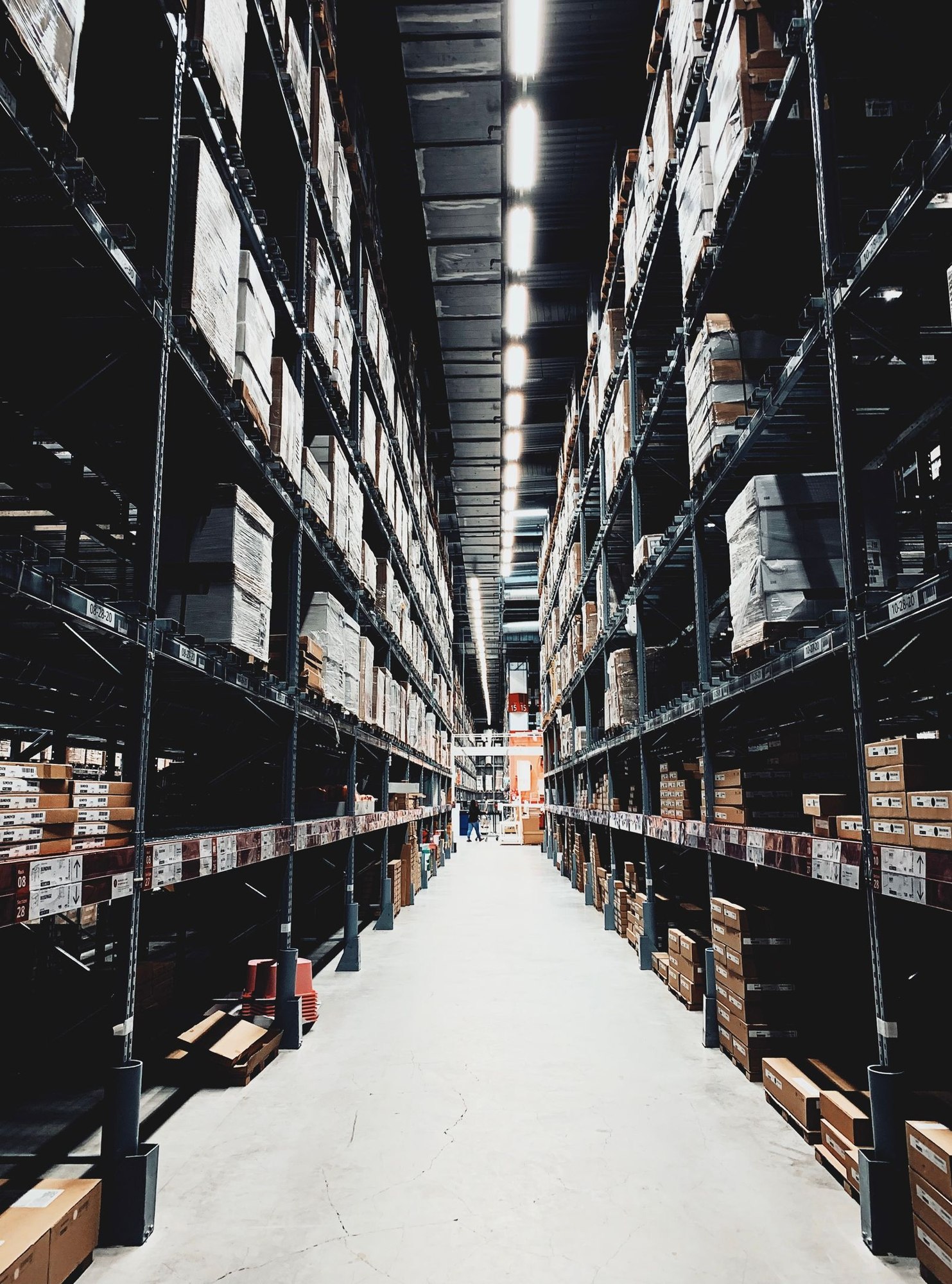 Warehouse aisle between tall stocked storage racks